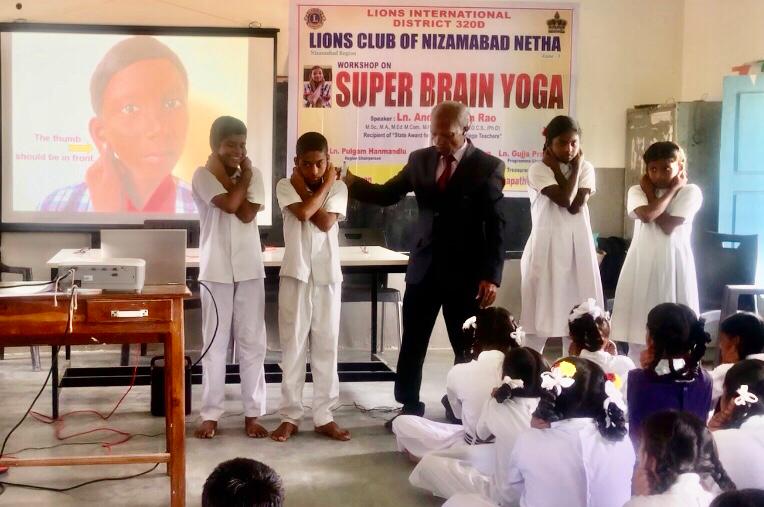 Demonstration of positioning of fingers on earlobes- Workshop on Super Brain Yoga at Zilla Parishad High School, Suddapally, Dichpally Mandal, Nizamabad Dist. The program was sponsored by International Lions Club of Nizamabad-Netha.